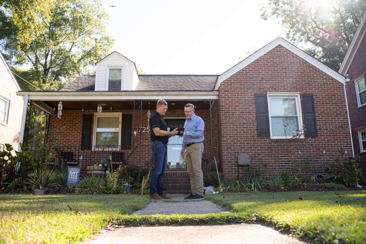 inspector meeting with homeowner in front yard of residence
