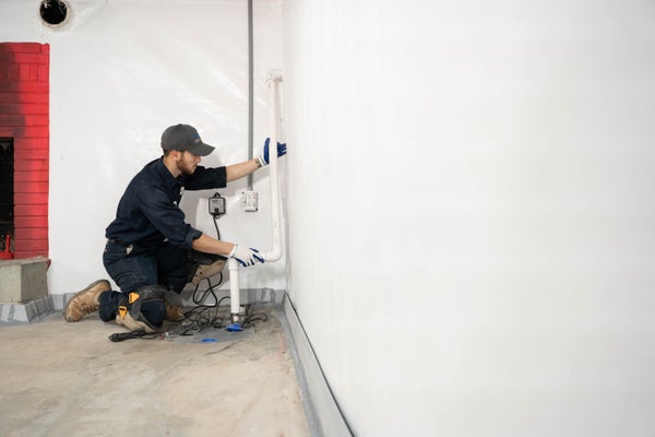 Groundworks crew installing basement sump pump