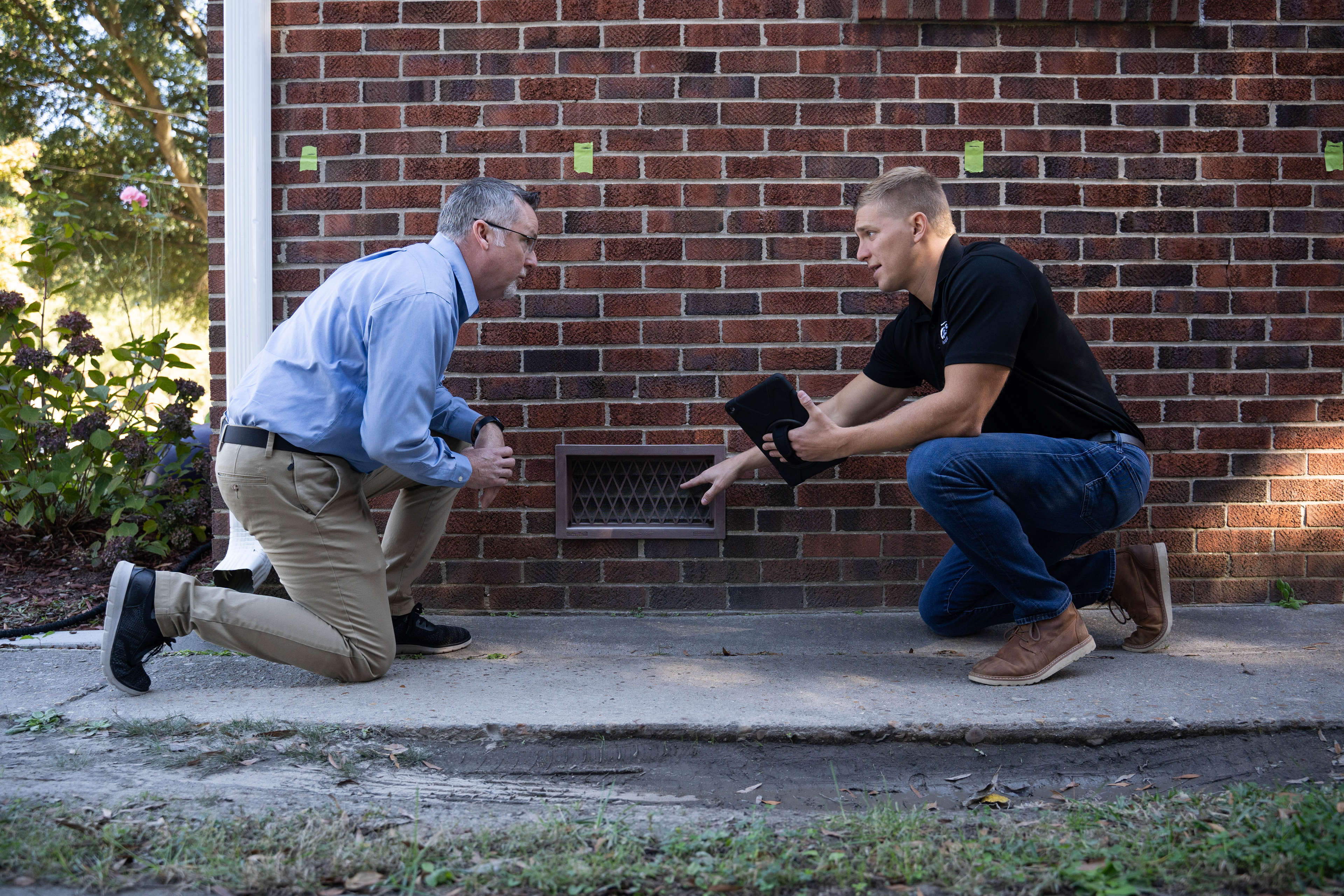 JES Foundation Repair inspector assessing crawl space door with homeowner