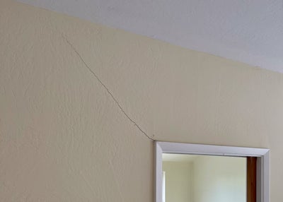 Cracking drywall around a door frame.