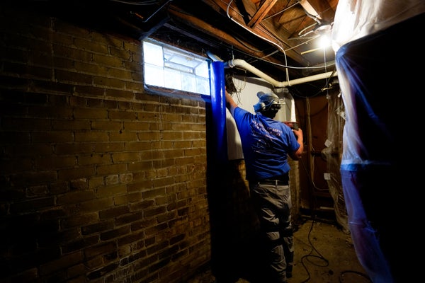 Groundworks crew installing basement egress window