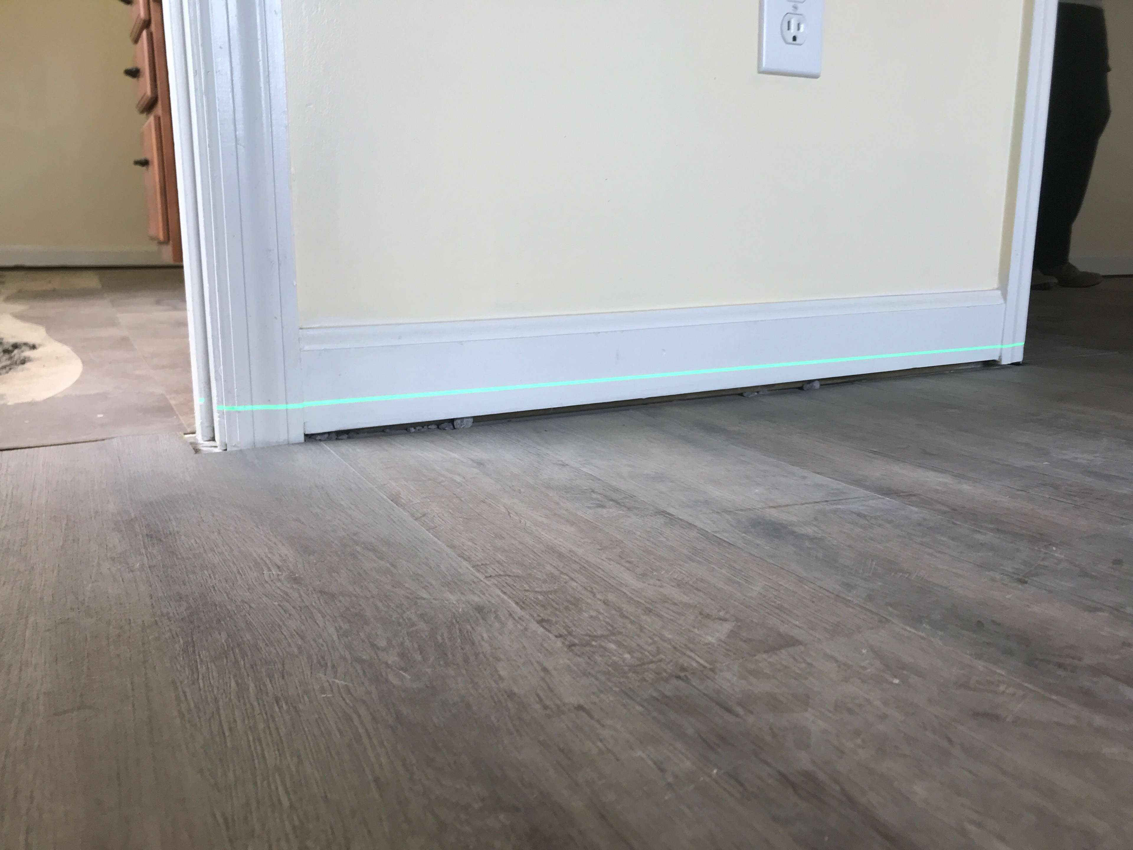laser level indicating an unlevel floor and a gap between the wall and floor