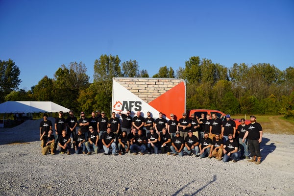 AFS Repair team standing by branded truck on gravel road