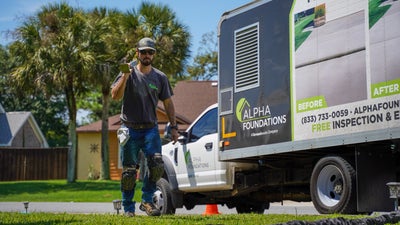 Alpha installer walking with pier behind shoulder.