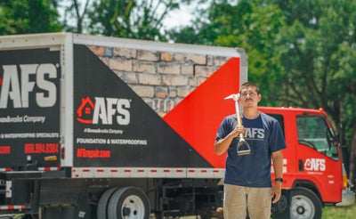 AFS crew member standing in front of a company truck