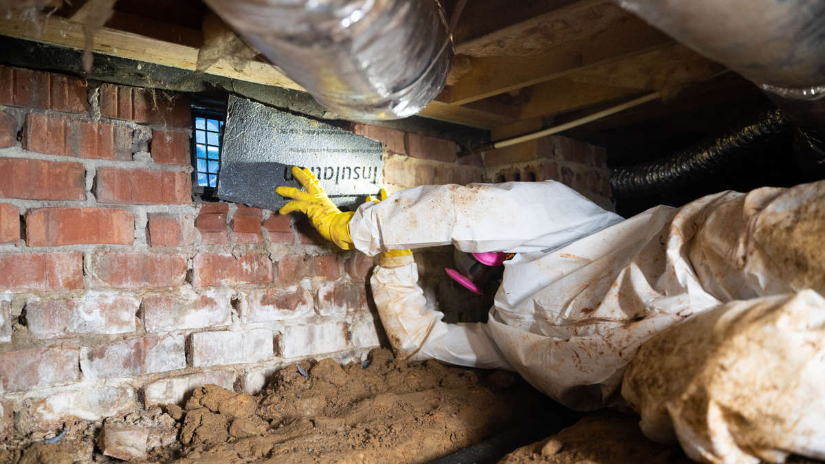 Installing crawl space vent sealing.