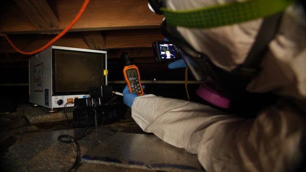 crew measuring crawl space humidity with tools