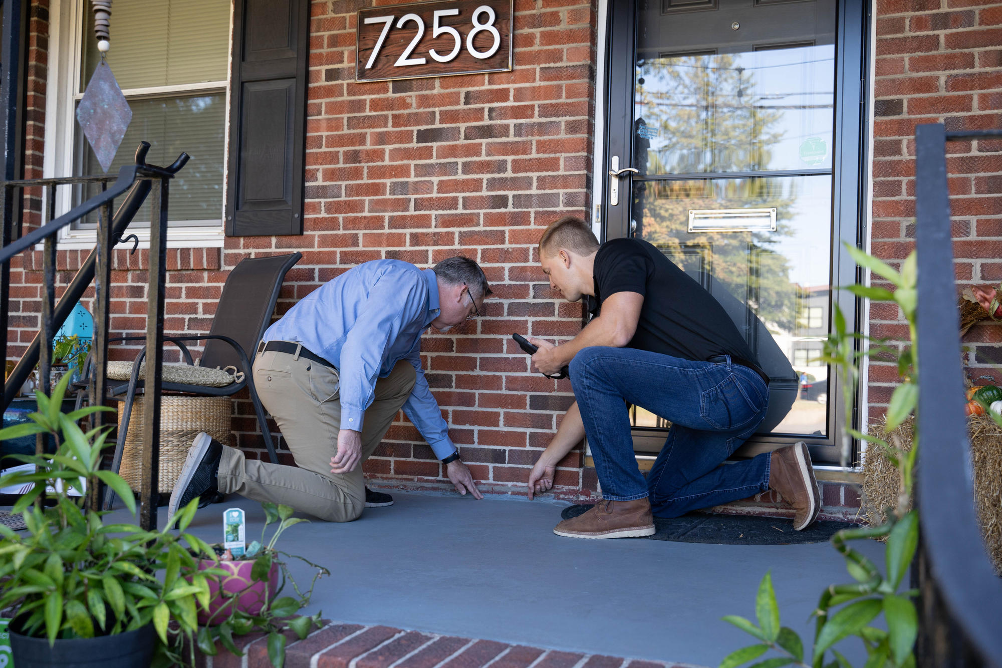 JES Foundation Repair inspector and homeowner assessing front porch of house