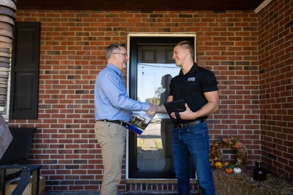 JES Foundation Repair inspector shaking hands with homeowner on porch