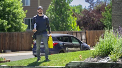 Groundworks inspector standing in front of a house and company car