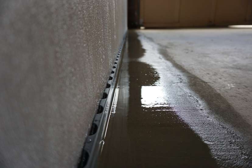 Water draining into a basement drainage system.