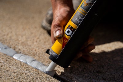 Concrete being sealed with caulk.