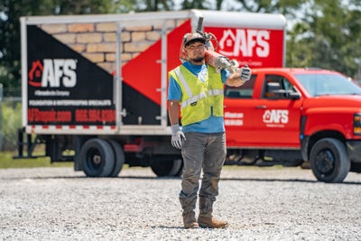 AFS crew member standing in front of a company truck