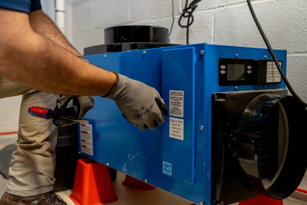 close-up of mans arm holding basement dehumidifer