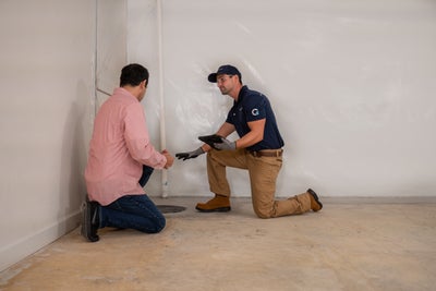 Groundworks inspector explaining basement waterproofing to a homeowner
