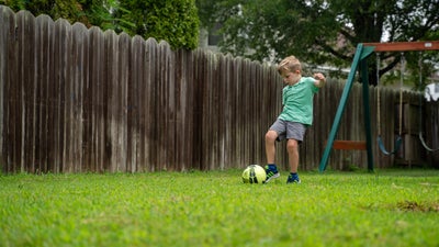 boy playing in yard with soccer ball