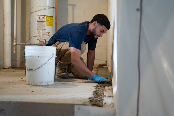 A Groundworks CFI waterproofing a basement.