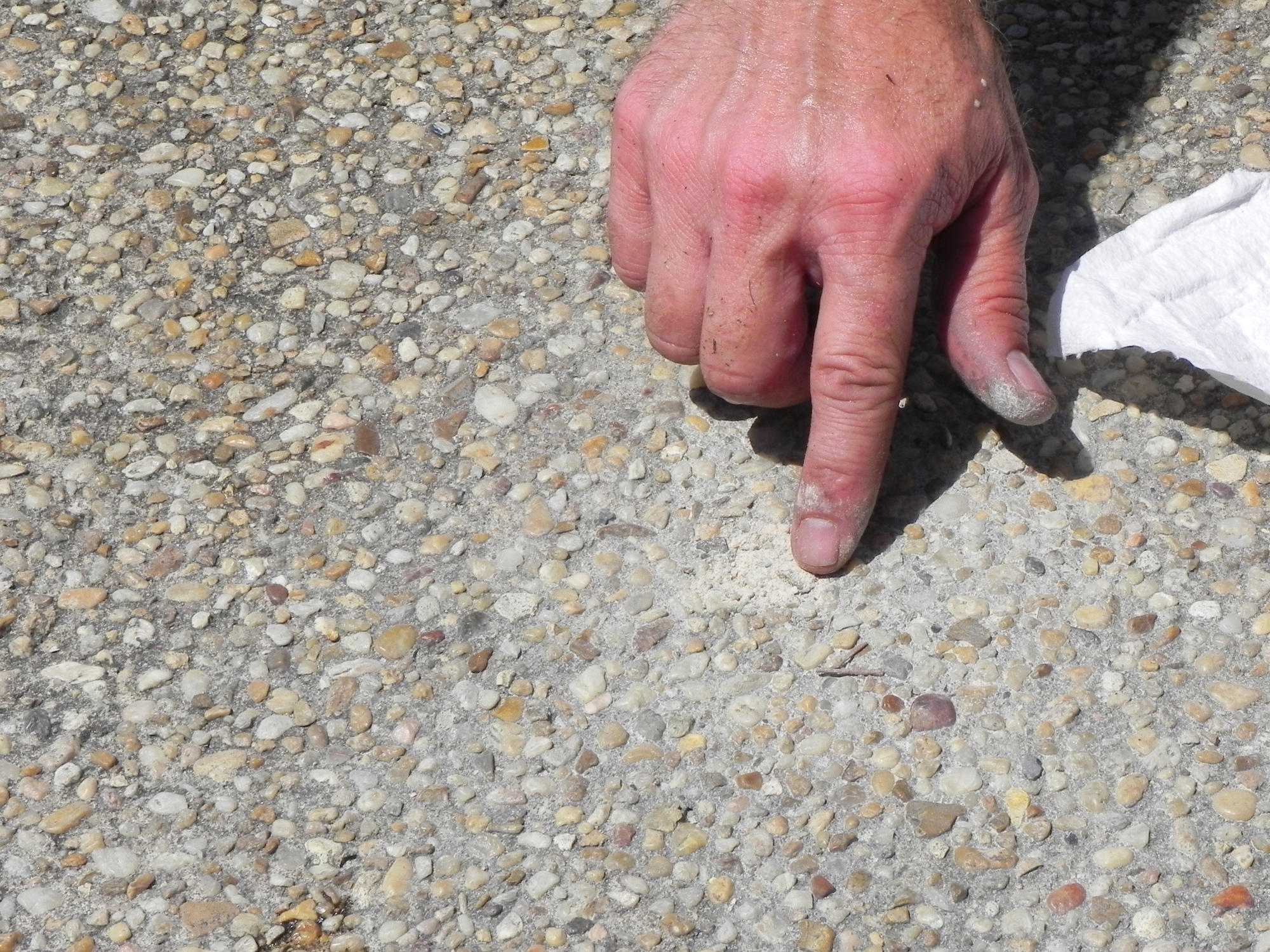 crew member fills a drilled hole in concrete