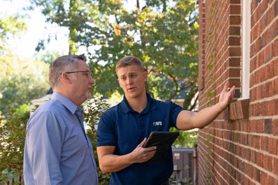 AFS inspector pointing out foundation issues to a homeowner