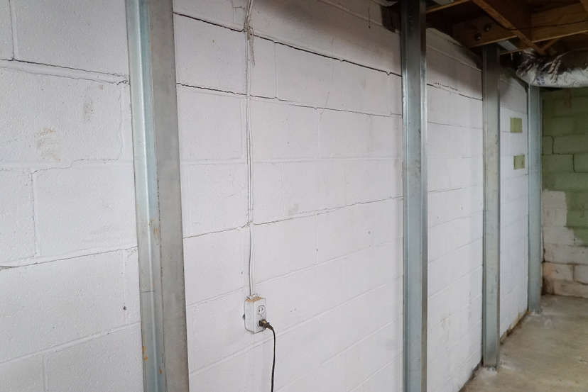 Steel I-beams supporting a block basement wall.