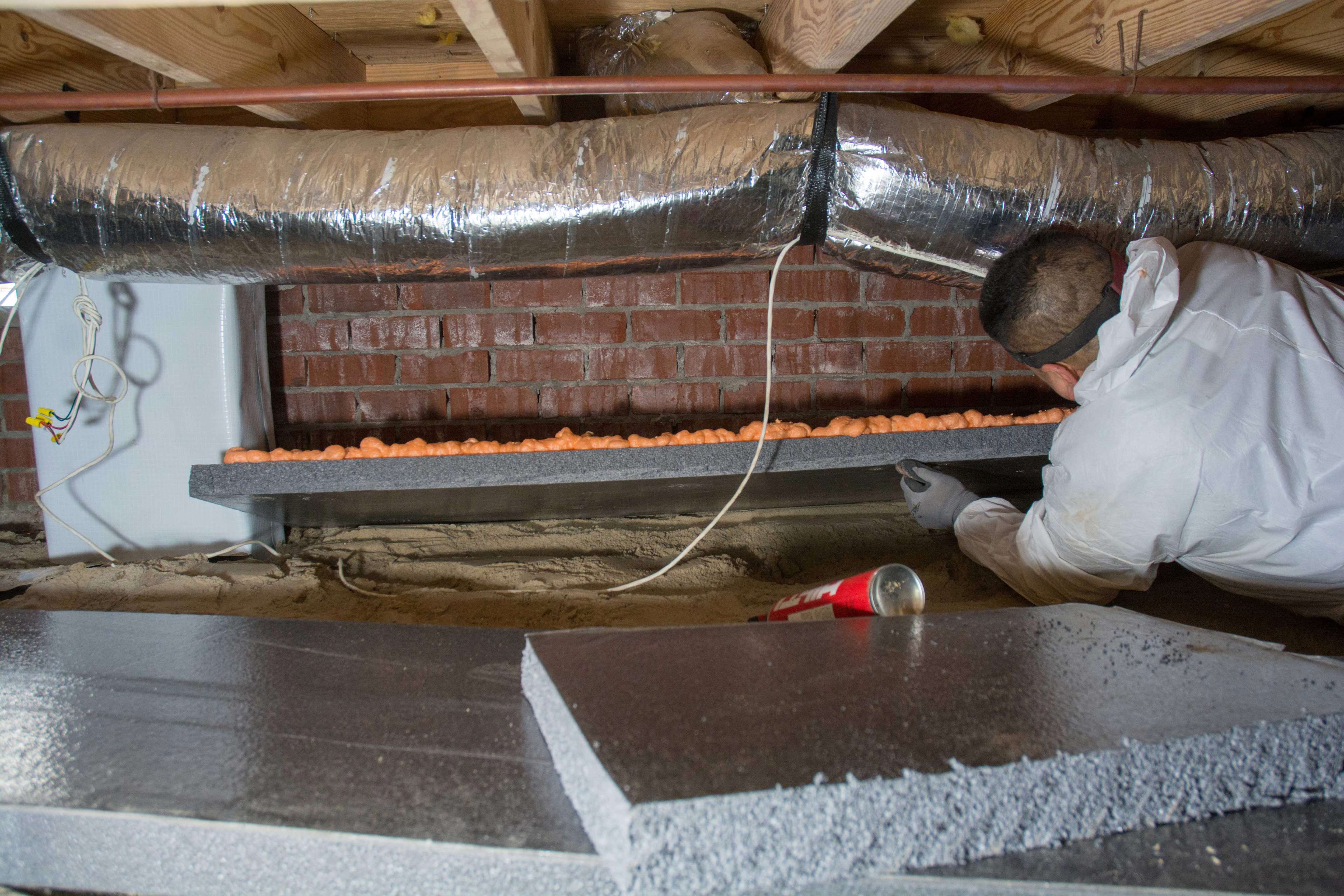 crew member installs extremebloc panels on crawl space walls