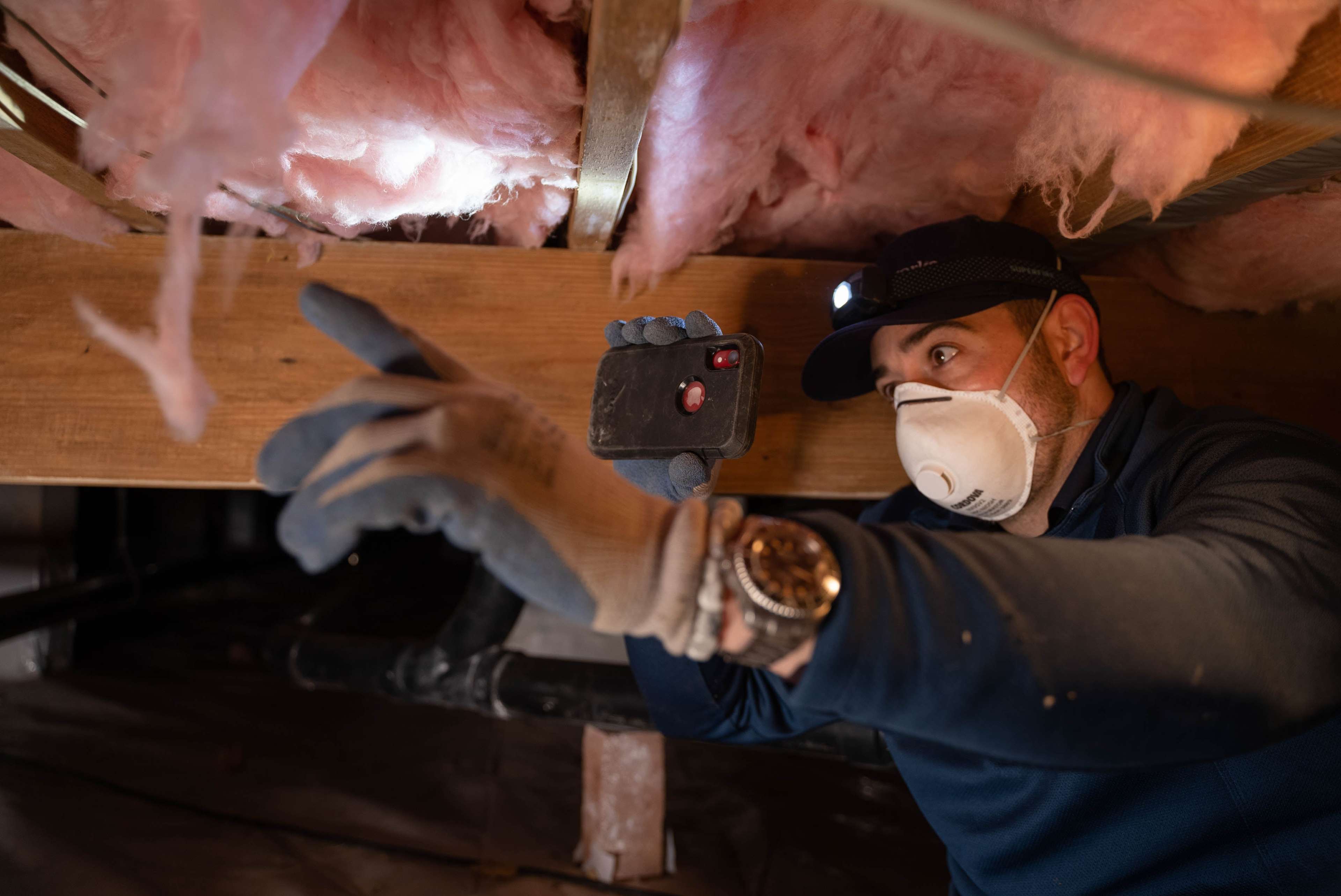 inspector looking at insulation in a crawl space