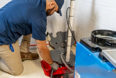 service technician cleaning a basement sump pump system