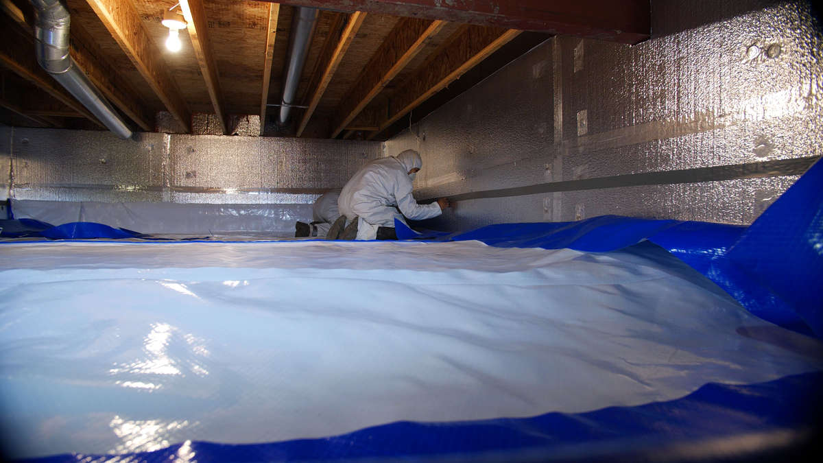crew installing vapor barrier for crawl space encapsulation