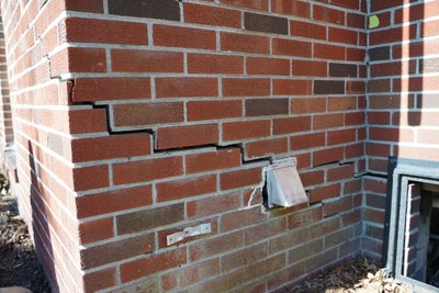 Large crack in a brick wall due to foundation settlement.