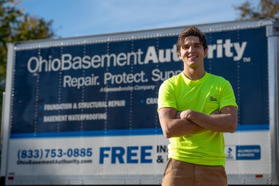 Ohio Basement Authority crew member standing in front of a company truck