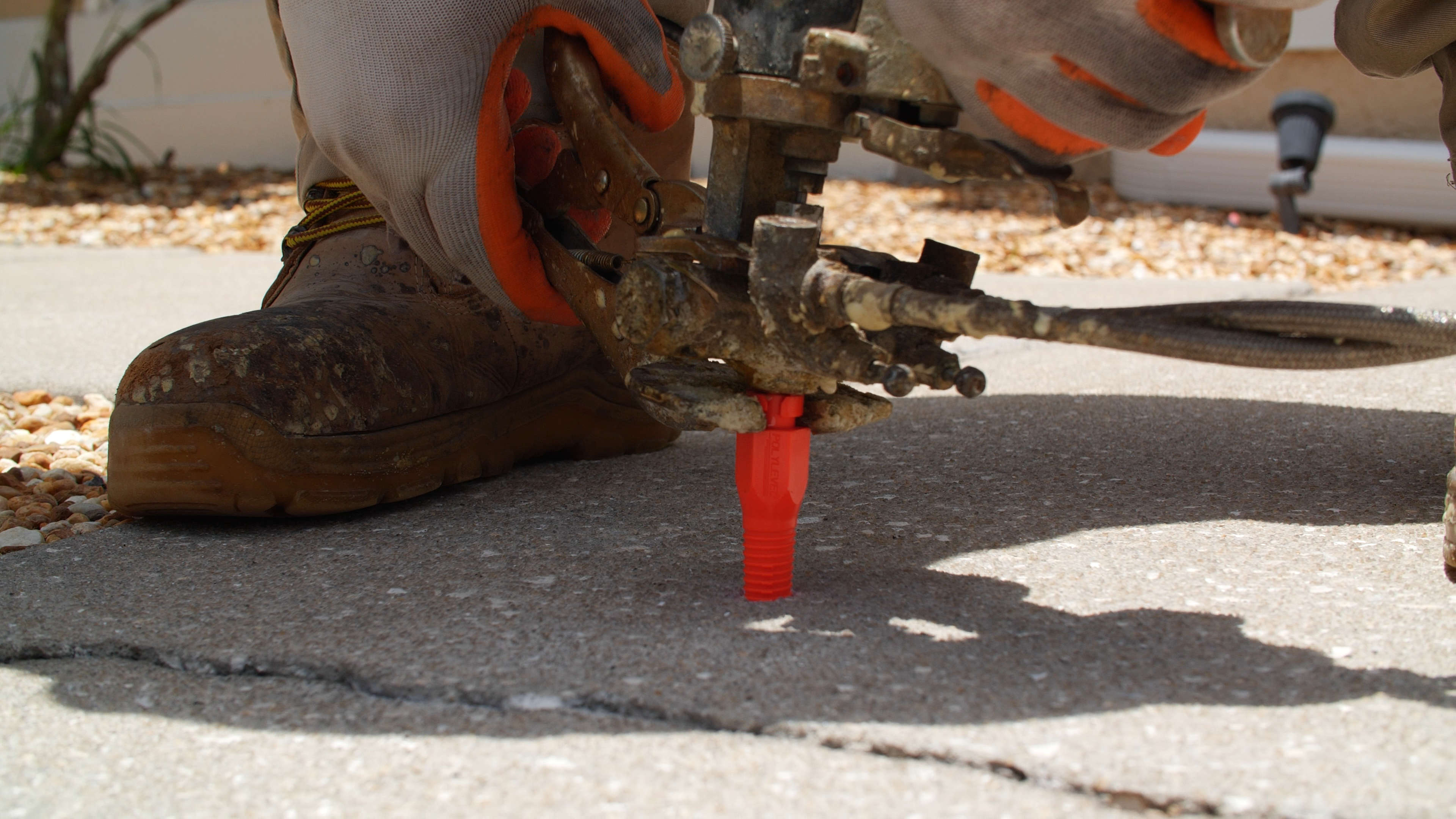 closeup of equipment used to pump polyurethane foam under concrete