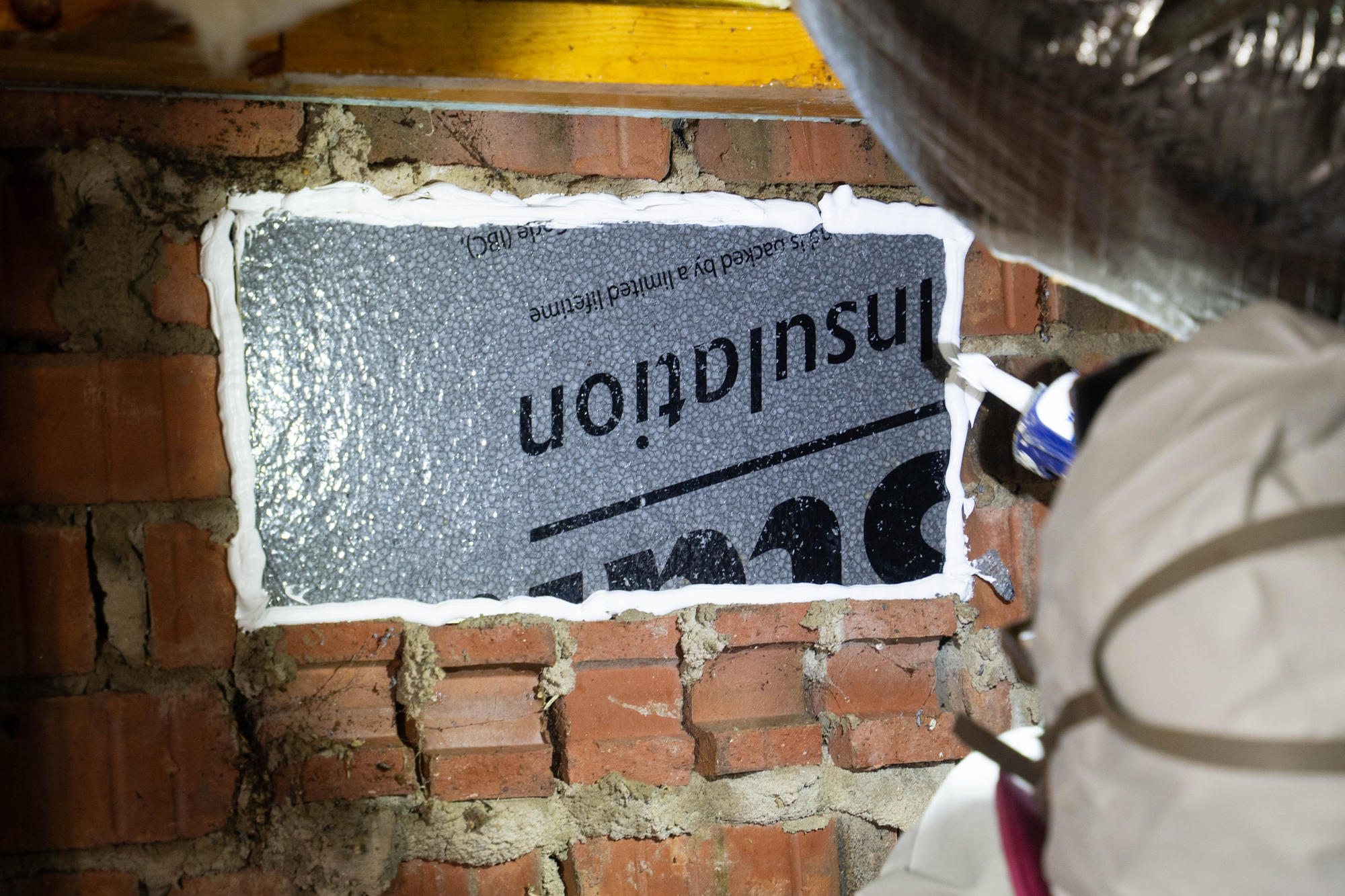 crew member blocks off a crawl space vent