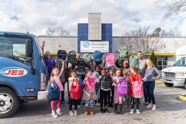 JES employees delivering backpacks to the Boys and Girls Club