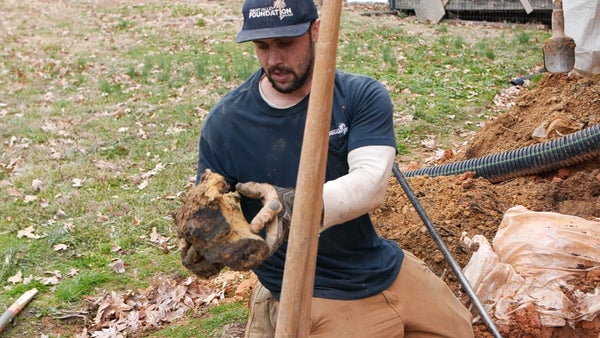 Mount Valley Foundation Services crew inspecting item from soil