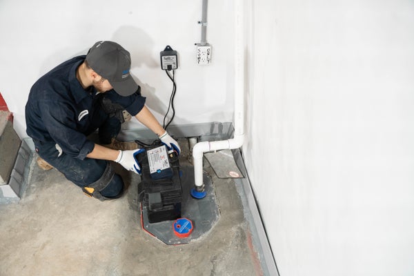 JES crew installing a sump pump in basement