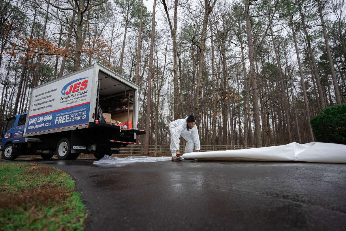 JES work truck and crew member with vapor barrier roll
