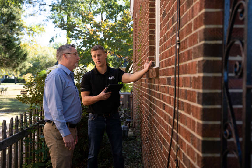 JES inspector showing a homeowner exterior damage to their home.