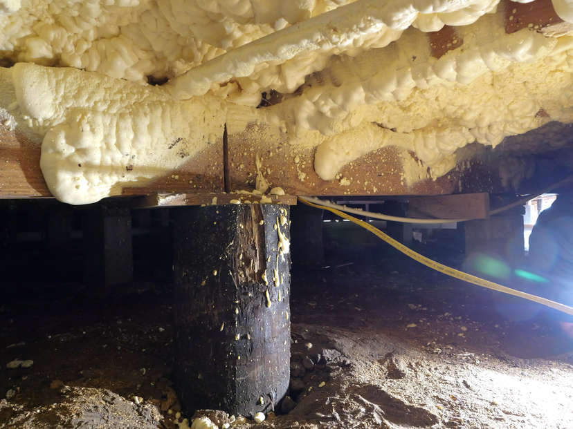 spray foam insulation on wooden crawl space beam rim joist