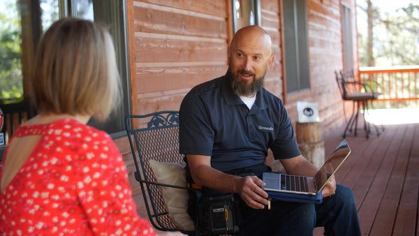 Groundworks inspector and homeowner sitting talking on front porch