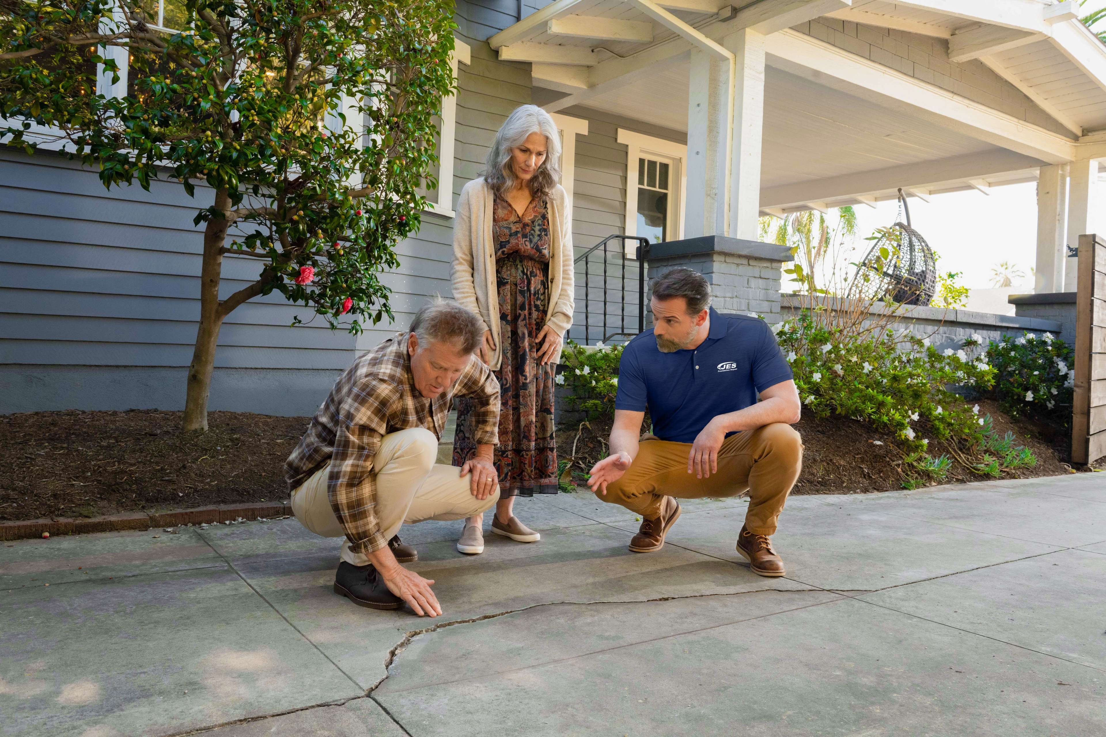 JES inspector points out concrete cracks to homeowners