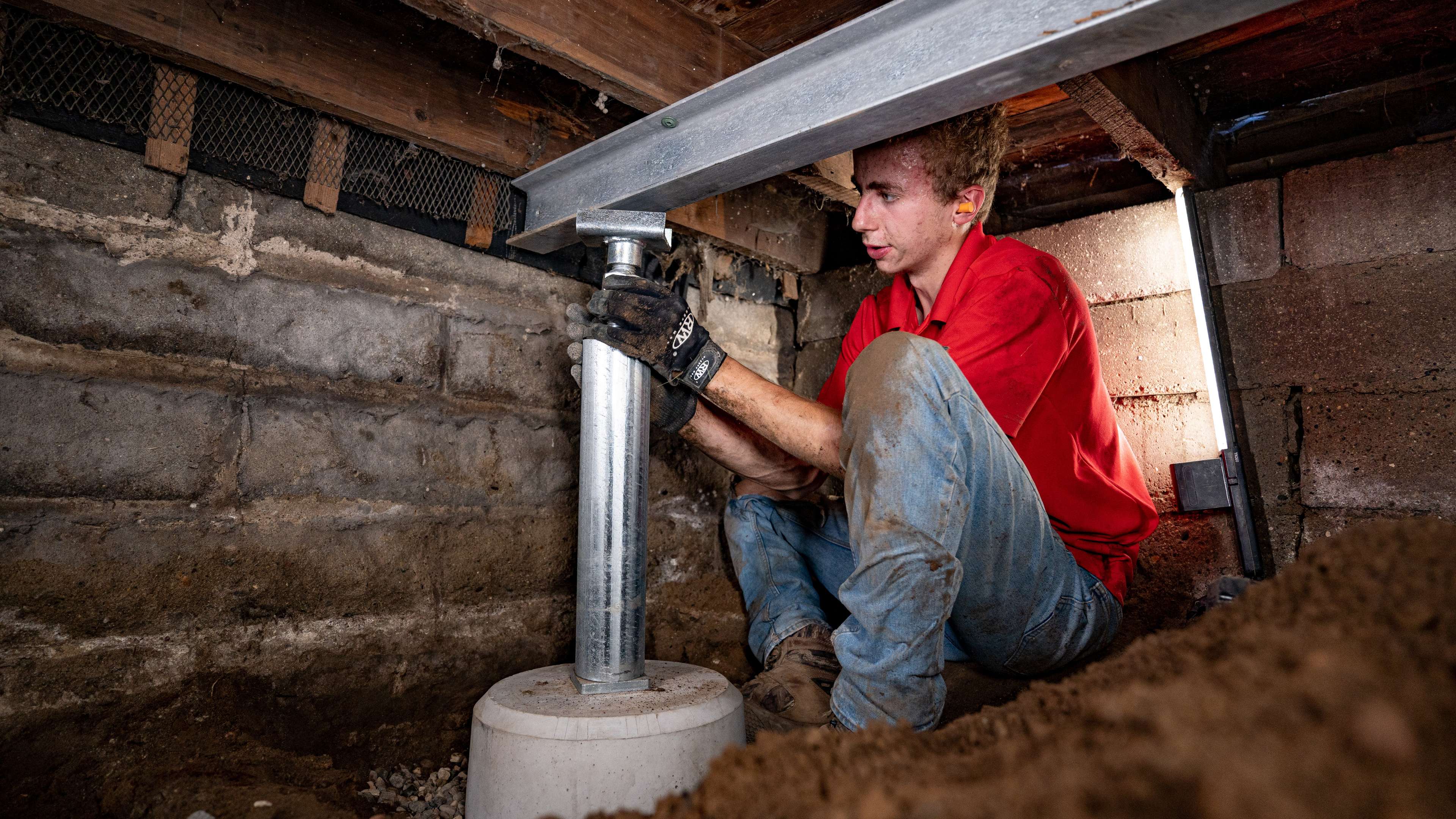 crew member installs crawl space jacks