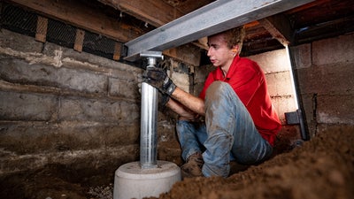 crew member installing a crawl space jack