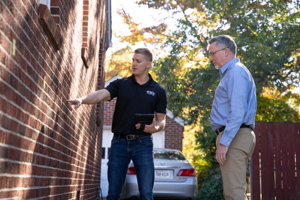 JES Foundation Repair inspector and homeowner assessing house