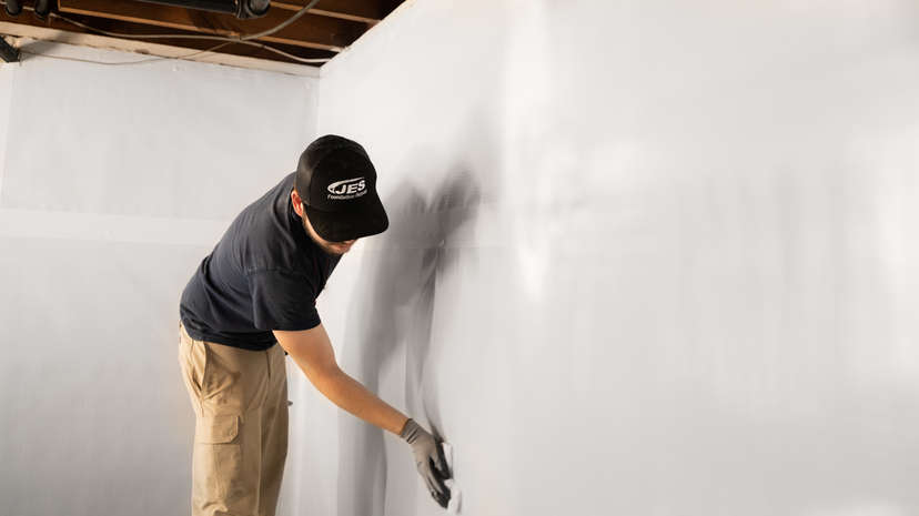 JES installer wiping down a basement wall.