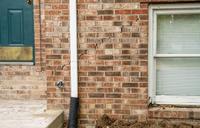 Exterior brick wall with cracks.