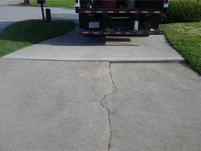 Cracked and sinking uneven driveway.