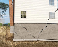 Close-up of cracked basement foundation and separating chimney.