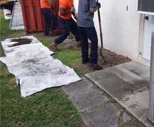 Production crew grading exterior foundation.