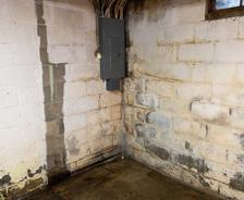 Damp and leaking basement corner wall and floor.