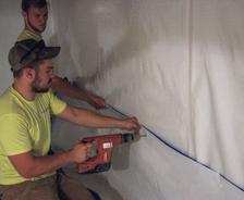 Crew installing crawlspace vapor barrier.